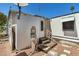 Exterior back view of the manufactured home showing utility access and small back steps at 4065 E University Dr # 228, Mesa, AZ 85205