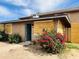Exterior view of home with boarded windows and bougainvillea bush at 4242 N 69Th Dr # 1303, Phoenix, AZ 85033