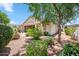 Well-kept backyard with desert landscaping, a covered patio, and a mature tree, creating a serene outdoor space at 4414 W Monte Way, Laveen, AZ 85339