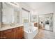 Bright bathroom with double sinks, soaking tub, and natural lighting at 4414 W Monte Way, Laveen, AZ 85339