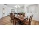Elegant dining room with hardwood floors, plantation shutters, and an ornate chandelier above the dining table at 4414 W Monte Way, Laveen, AZ 85339