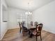 Formal dining room featuring hardwood floors, plantation shutters, an elegant chandelier, and a large wood dining table at 4414 W Monte Way, Laveen, AZ 85339