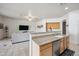 Bright and modern kitchen featuring a stainless steel dishwasher and a bar overlooking the living space at 4414 W Monte Way, Laveen, AZ 85339