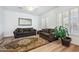 Cozy living room showcasing hardwood floors, plantation shutters, comfortable seating, and a decorative rug at 4414 W Monte Way, Laveen, AZ 85339