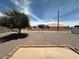 Backyard features an open gravel space with mature trees and perimeter fencing at 513 S Cardinal Dr, Apache Junction, AZ 85120