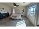 Bright bedroom featuring neutral walls and carpet, complemented by a ceiling fan and natural light from a large window at 5306 N 188Th Ln, Litchfield Park, AZ 85340