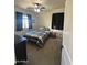 Inviting bedroom with a checkered comforter, ceiling fan, and natural light from a window at 5306 N 188Th Ln, Litchfield Park, AZ 85340