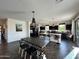 Open-concept kitchen with black cabinets, island seating, and plenty of natural light at 5306 N 188Th Ln, Litchfield Park, AZ 85340