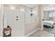Modern bathroom featuring a glass-enclosed shower, neutral tile, and access to the main bedroom at 549 E Balao Dr, Phoenix, AZ 85085