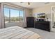 Bright bedroom with a large window overlooking the pool, a TV, and dark wood furniture at 549 E Balao Dr, Phoenix, AZ 85085