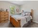 Relaxing bedroom featuring a bed with soft gray bedding, a window with lush greenery, and a dresser at 549 E Balao Dr, Phoenix, AZ 85085