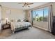 Comfortable bedroom featuring a cozy bed, neutral tones, carpeted floors and a large window with backyard views at 549 E Balao Dr, Phoenix, AZ 85085