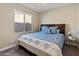 Cozy bedroom featuring a comfortable bed with blue accents and a view of the backyard through the window at 549 E Balao Dr, Phoenix, AZ 85085