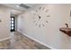 Hallway with wood-look tile flooring, a large clock, and access to various rooms at 549 E Balao Dr, Phoenix, AZ 85085