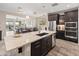 Modern kitchen with a large granite island, stainless steel appliances, and dark cabinets at 549 E Balao Dr, Phoenix, AZ 85085