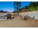 Outdoor dining set and barbecue grill in the landscaped backyard at 6216 W Poinsettia Dr, Glendale, AZ 85304