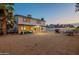 Wide view of the property showing the house, covered patio, grill, and string lights at 6216 W Poinsettia Dr, Glendale, AZ 85304