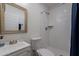 A bathroom including a toilet, shower with white tile, and a vanity with mirror at 6216 W Poinsettia Dr, Glendale, AZ 85304