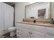 Bathroom featuring double sinks, a large framed mirror, tub-shower combo, and a toilet at 6216 W Poinsettia Dr, Glendale, AZ 85304