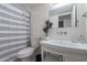 A bathroom with a vanity with a vessel sink, mirror, toilet, and tiled tub-shower combo at 6216 W Poinsettia Dr, Glendale, AZ 85304