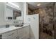 Bathroom with a vanity with a tile countertop and colorful sink with a shower behind a white wall at 6216 W Poinsettia Dr, Glendale, AZ 85304