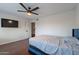 Bedroom boasts wood floors, natural lighting, and a large wall-mounted television at 6216 W Poinsettia Dr, Glendale, AZ 85304