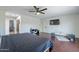 Bedroom boasts wood floors, bright lighting, a ceiling fan, and a wall-mounted television at 6216 W Poinsettia Dr, Glendale, AZ 85304
