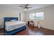 Bright bedroom features wood floors, a ceiling fan, and a built-in desk near the window at 6216 W Poinsettia Dr, Glendale, AZ 85304