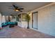 Relax in style on this covered patio with tile flooring, a ceiling fan, and comfortable outdoor seating at 6216 W Poinsettia Dr, Glendale, AZ 85304