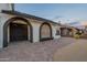 Home exterior with arched doorways, brick-paved walkway, and landscaped desert front yard at 6216 W Poinsettia Dr, Glendale, AZ 85304