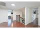 Hallway featuring wood floors and views to an office and stairwell at 6216 W Poinsettia Dr, Glendale, AZ 85304