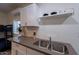 Modern kitchenette featuring white cabinets, countertop, and a plant at 6216 W Poinsettia Dr, Glendale, AZ 85304