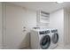A laundry room with a white door and a new front-load washing machine and dryer at 6216 W Poinsettia Dr, Glendale, AZ 85304