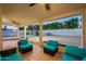 Spacious covered patio with comfortable lounge seating and ceiling fans, overlooking the expansive backyard at 6216 W Poinsettia Dr, Glendale, AZ 85304