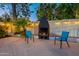 Cozy outdoor fireplace with chairs, creating a warm and inviting atmosphere for gatherings at 6216 W Poinsettia Dr, Glendale, AZ 85304