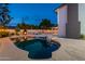 Backyard pool featuring a baja shelf with a view of the house and outdoor fireplace at 6216 W Poinsettia Dr, Glendale, AZ 85304