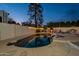 Inviting pool area with an outdoor fireplace and string lights for evening ambiance at 6216 W Poinsettia Dr, Glendale, AZ 85304