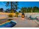 Backyard pool area with fireplace, seating, and lush landscaping for outdoor enjoyment at 6216 W Poinsettia Dr, Glendale, AZ 85304