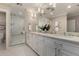 Bright bathroom with double vanity, marble countertops, walk-in shower, and white honeycomb tile flooring at 709 E Hayward Ave, Phoenix, AZ 85020