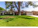 Charming single story home with a lush green lawn and mature shade tree in the front yard at 709 E Hayward Ave, Phoenix, AZ 85020