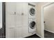 This laundry room features a stacked washer and dryer, along with ample storage in the bright, white cabinetry at 709 E Hayward Ave, Phoenix, AZ 85020