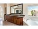 This bathroom features dual sinks, granite countertops, a soaking tub, and natural light at 720 W Palo Verde St, Gilbert, AZ 85233