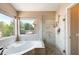 Bright bathroom featuring a soaking tub, and a separate glass-enclosed shower with natural light at 720 W Palo Verde St, Gilbert, AZ 85233