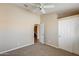 Neutral bedroom with carpeted floors, an ceiling fan, and a closet with a view to a bathroom at 720 W Palo Verde St, Gilbert, AZ 85233