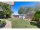 Exterior photo shows a spacious backyard with grass, mature trees and flowers at 7210 W Caron Dr, Peoria, AZ 85345