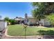 Spacious backyard with well-maintained lawn, desert plants, and a covered patio at 7210 W Caron Dr, Peoria, AZ 85345