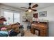 Cluttered Bedroom with a ceiling fan, writing desk, and window offering natural light at 7210 W Caron Dr, Peoria, AZ 85345