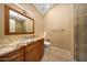 Well-lit bathroom featuring stone countertops, wooden cabinets, and a glass shower at 7272 E Gainey Ranch Rd # 23, Scottsdale, AZ 85258