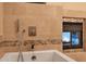 Large bathtub with stylish fixtures and fireplace for a luxurious bathing experience at 7272 E Gainey Ranch Rd # 23, Scottsdale, AZ 85258