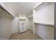 Bright walk-in closet with custom shelving and drawers for storage at 7272 E Gainey Ranch Rd # 23, Scottsdale, AZ 85258